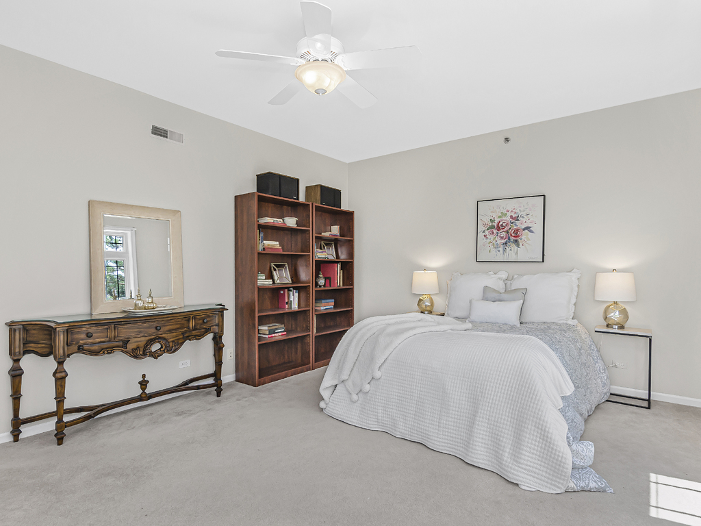 9200 East Prairie Road, Unit 403 Evanston, IL 60203 - Photo 12 of 23 a spacious bedroom with a bed and a book shelf