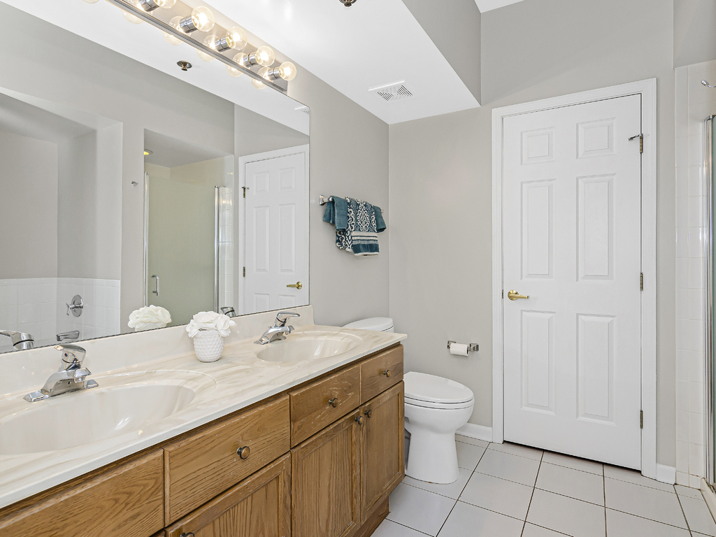 9200 East Prairie Road, Unit 403 Evanston, IL 60203 - Photo 14 of 23 a bathroom with a granite countertop sink a toilet and a mirror
