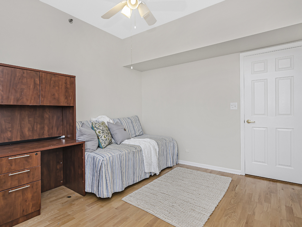 9200 East Prairie Road, Unit 403 Evanston, IL 60203 - Photo 17 of 23 a living room with a bed furniture and a wooden floor