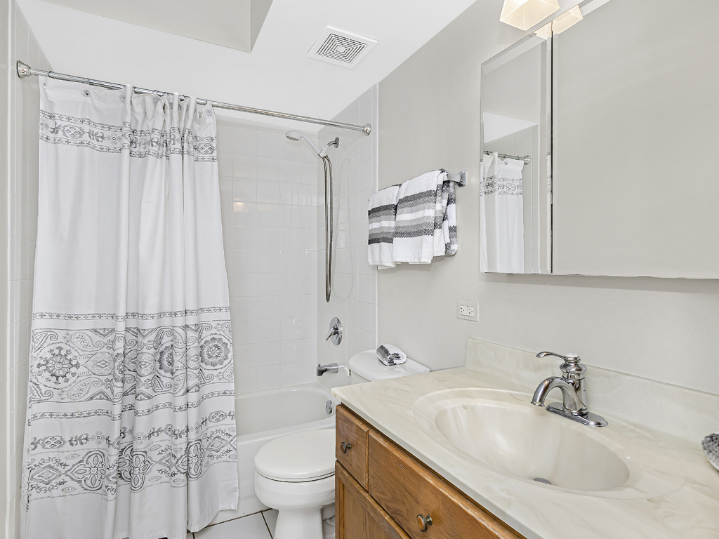 9200 East Prairie Road, Unit 403 Evanston, IL 60203 - Photo 20 of 23 a bathroom with a sink a toilet and shower curtain