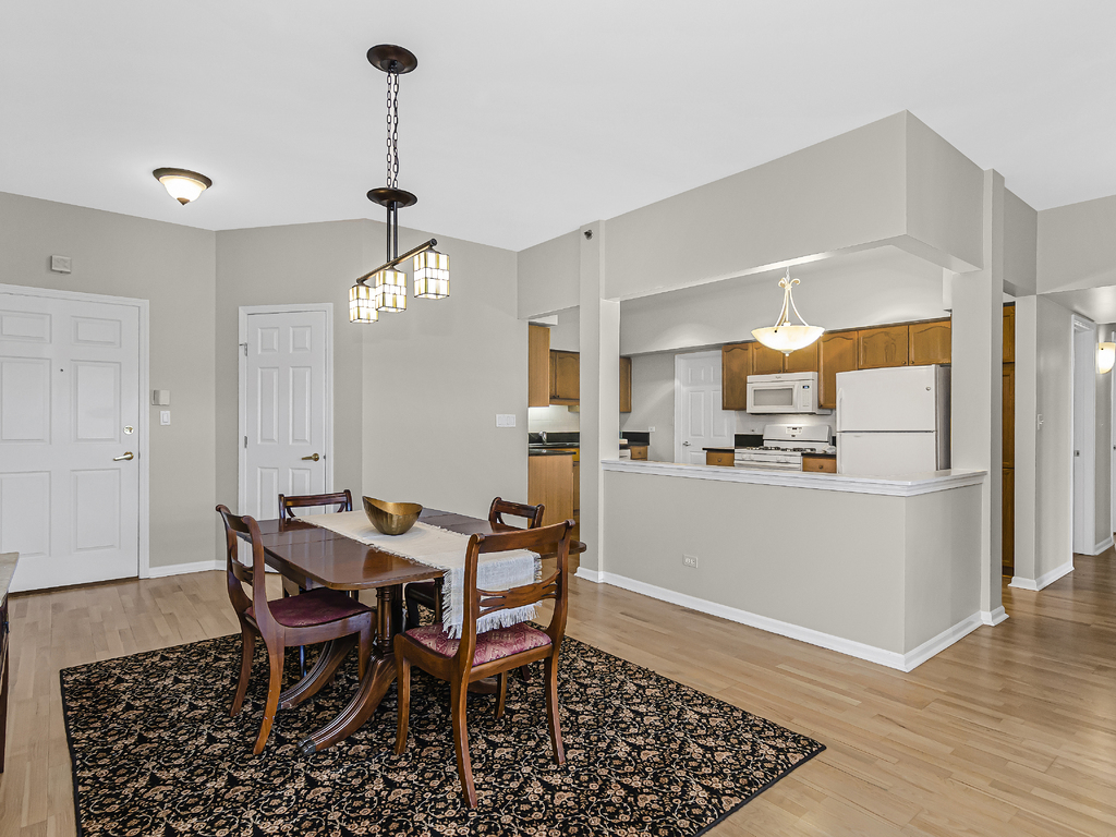 9200 East Prairie Road, Unit 403 Evanston, IL 60203 - Photo 4 of 23 a view of a dining room with furniture and wooden floor
