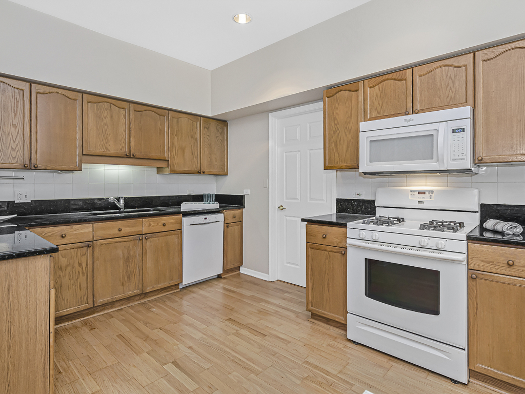9200 East Prairie Road, Unit 403 Evanston, IL 60203 - Photo 8 of 23 a kitchen with granite countertop cabinets stainless steel appliances and sink