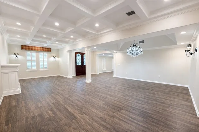 a view of an empty room with wooden floor fireplace and a window