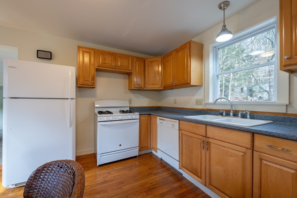 7 Depot Road Williamsburg, MA 01039 - Photo 13 of 29 a kitchen with stainless steel appliances granite countertop a refrigerator a sink dishwasher a stove and white countertops with wooden floor