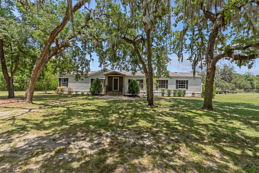 26255 Lambeth Road Brooksville, FL 34601 - Photo 1 of 76 a front view of a house with a garden