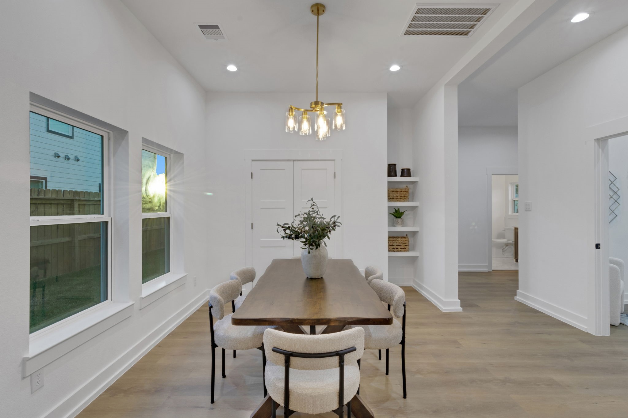 4202 Plaag Street Houston, TX 77016 - Photo 18 of 38 Bright dining space with large windows and an elegant chandelier, offering a welcoming setting for family meals and gatherings.