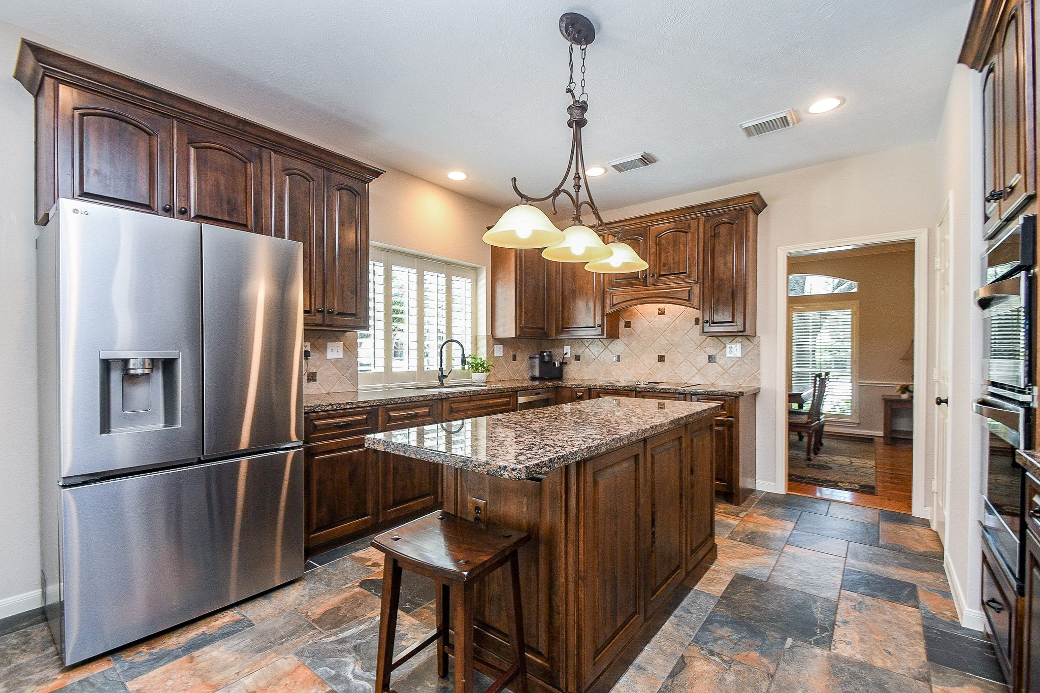 1703 Fall Ridge Circle Katy, TX 77494 - Photo 9 of 38 This remodeled kitchen features premium, rich wood cabinetry, high-end finishes, and an abundance of storage space throughout.