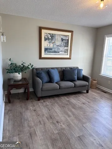 a living room with furniture and a wooden floor