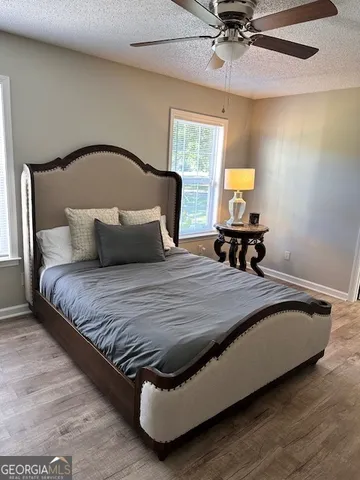 a bedroom with a bed a mirror and a flat tv screen on dresser