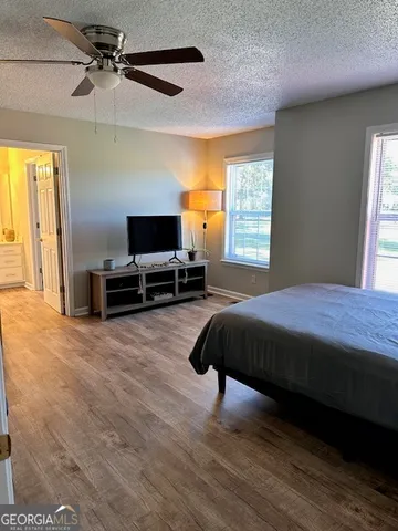a bedroom with a bed a flat screen tv and a chandelier