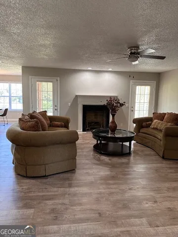 a living room with furniture a fireplace and a large window