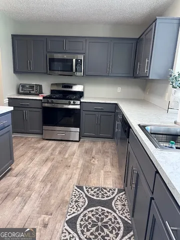 a kitchen with stainless steel appliances kitchen island granite countertop a sink stove and cabinets