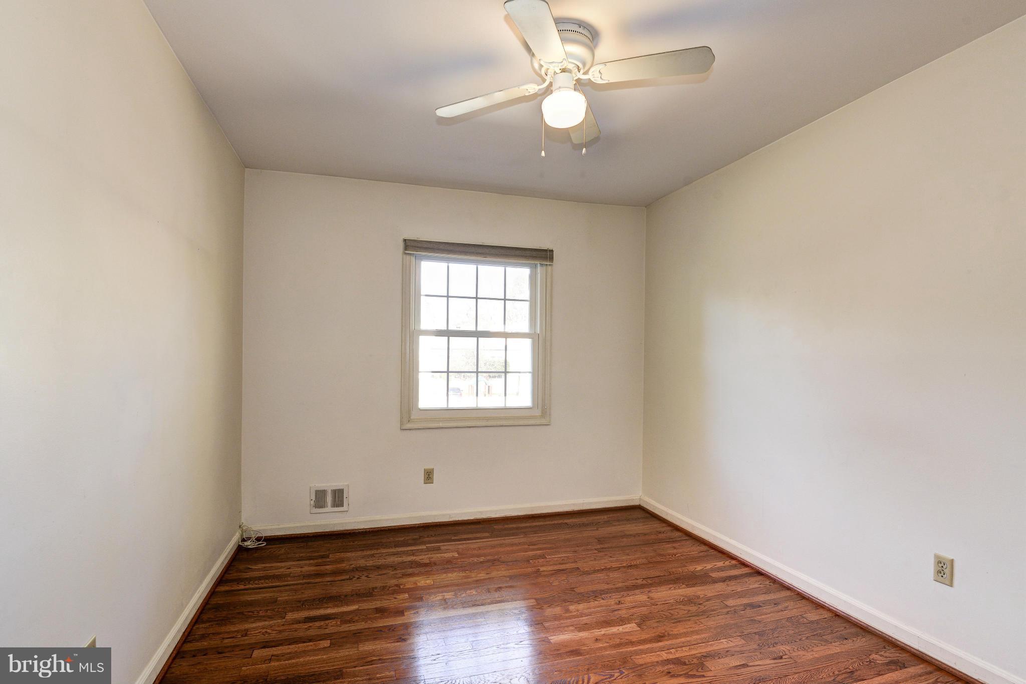 8306 Wickham Road Springfield, VA 22152 - Photo 18 of 29 an empty room with wooden floor fan and windows