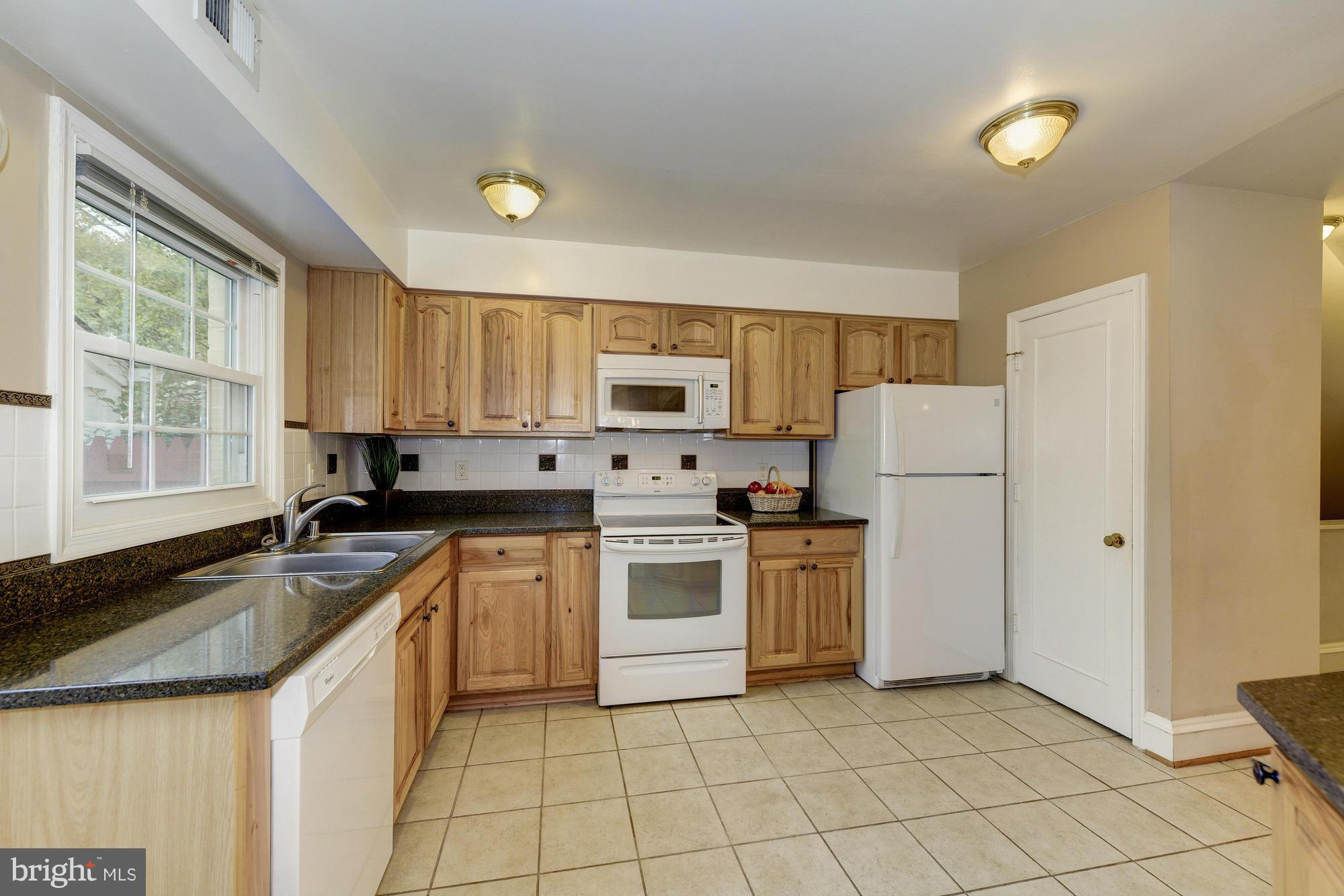 8306 Wickham Road Springfield, VA 22152 - Photo 10 of 29 a kitchen with a stove a sink and a refrigerator