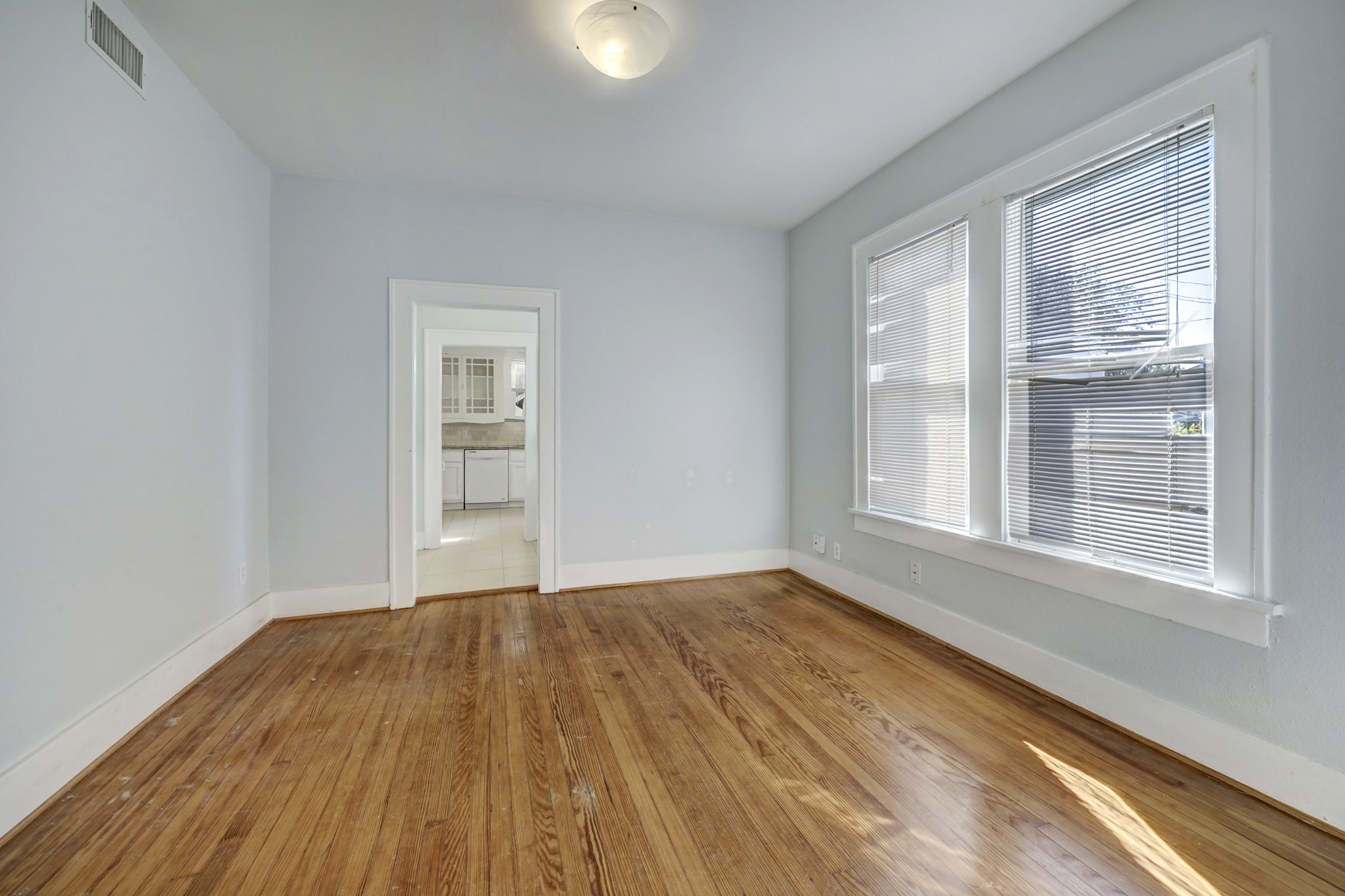 1649 West Main Street, Unit 3 Houston, TX 77006 - Photo 6 of 21 a view of an empty room with wooden floor and a window