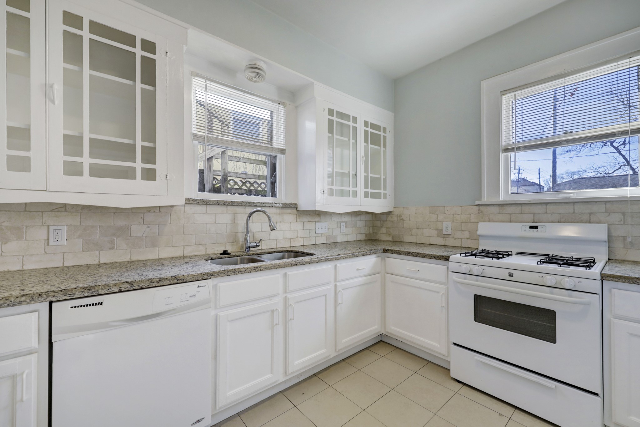 1649 West Main Street, Unit 3 Houston, TX 77006 - Photo 10 of 21 a kitchen with stainless steel appliances granite countertop white cabinets and window