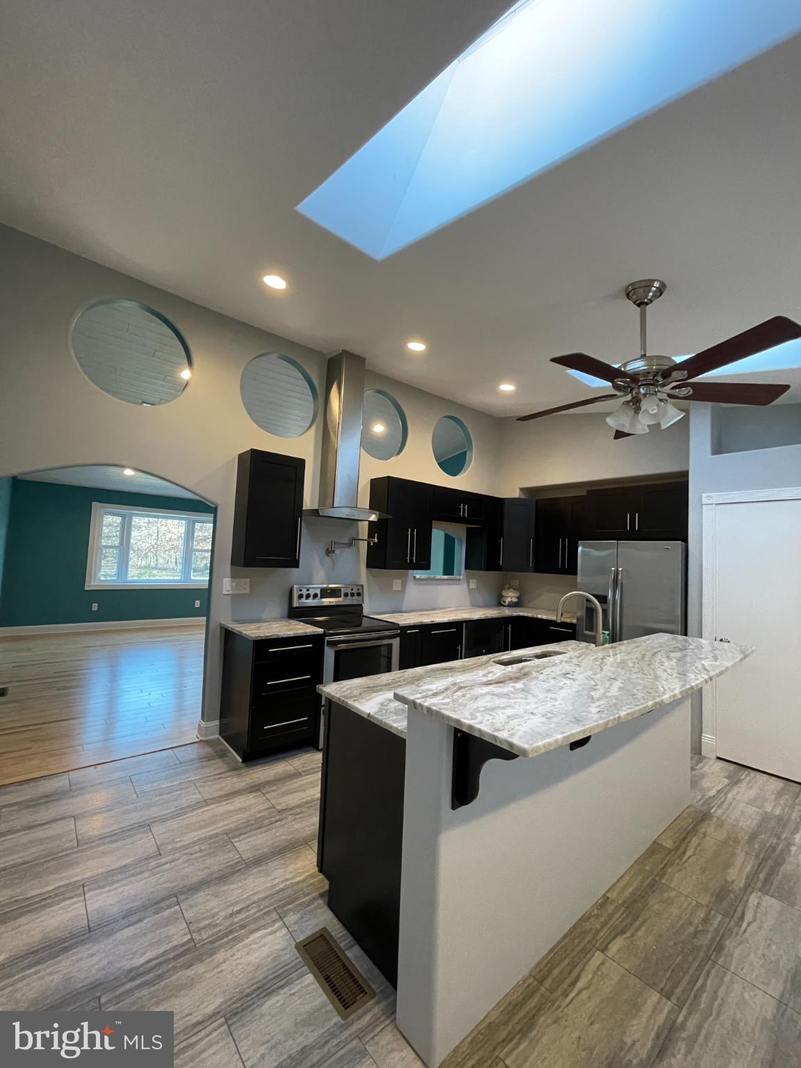 2883 Williamstown Road Franklinville, NJ 08322 - Photo 5 of 8 a large kitchen with stainless steel appliances granite countertop a stove top oven a sink dishwasher a dining table and chairs with wooden floor