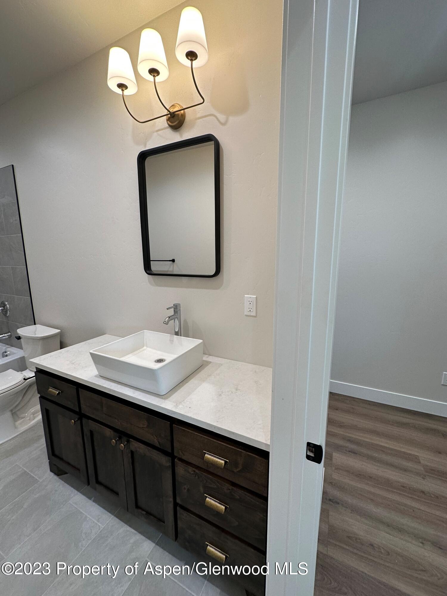 1351 Rifle Heights Drive Rifle, CO 81650 - Photo 6 of 8 a bathroom with a sink vanity and a mirror