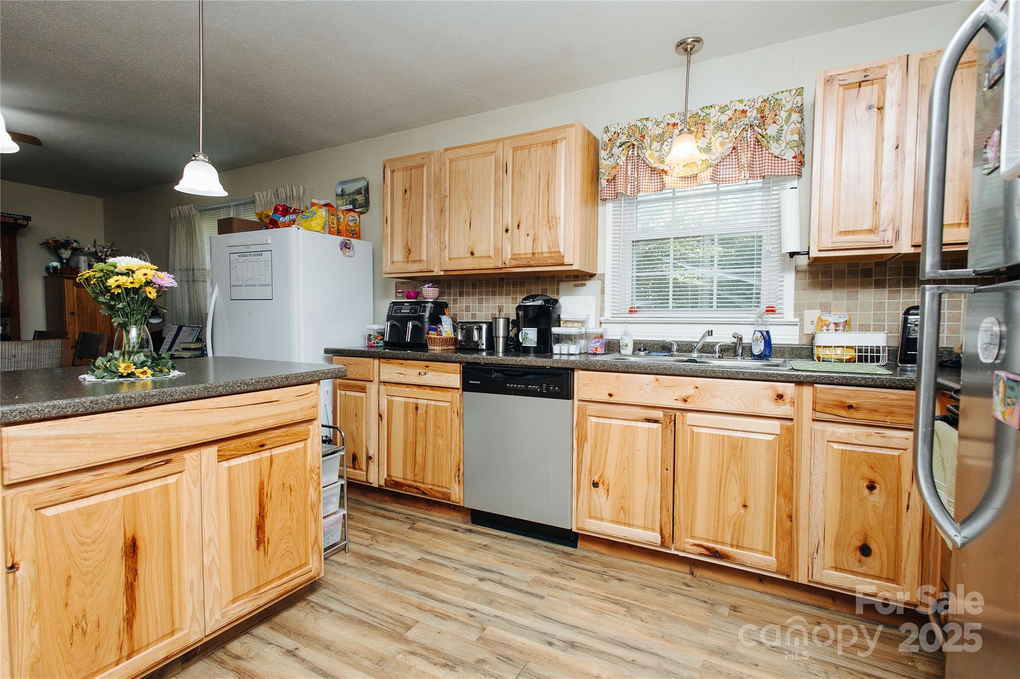 98 Long Street Marion, NC 28752 - Photo 23 of 30 a kitchen with stainless steel appliances granite countertop a stove a sink dishwasher and white cabinets with wooden floor
