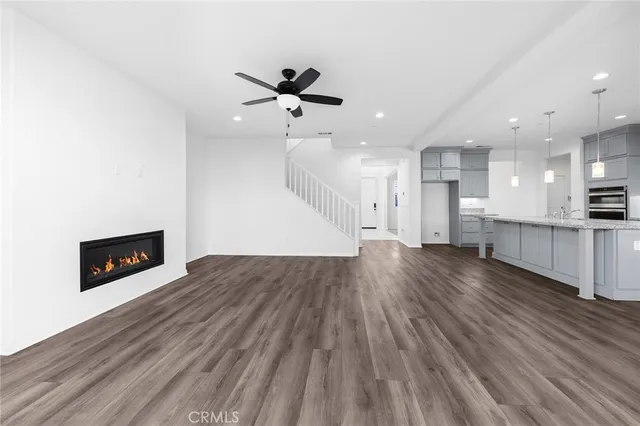 a large kitchen with stainless steel appliances kitchen island granite countertop a stove a sink and a wooden floors