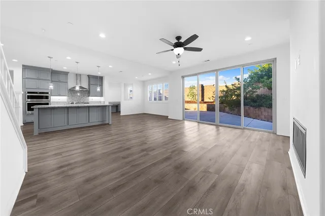 a large white kitchen with lots of counter space wooden cabinets and stainless steel appliances