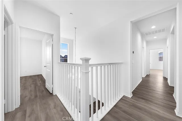 a view of a hallway with wooden floor and a window