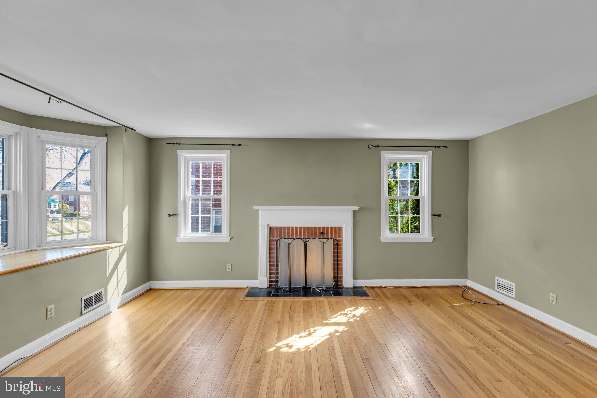 6147 Regent Park Road Catonsville, MD 21228 - Photo 3 of 22 an empty room with wooden floor and windows