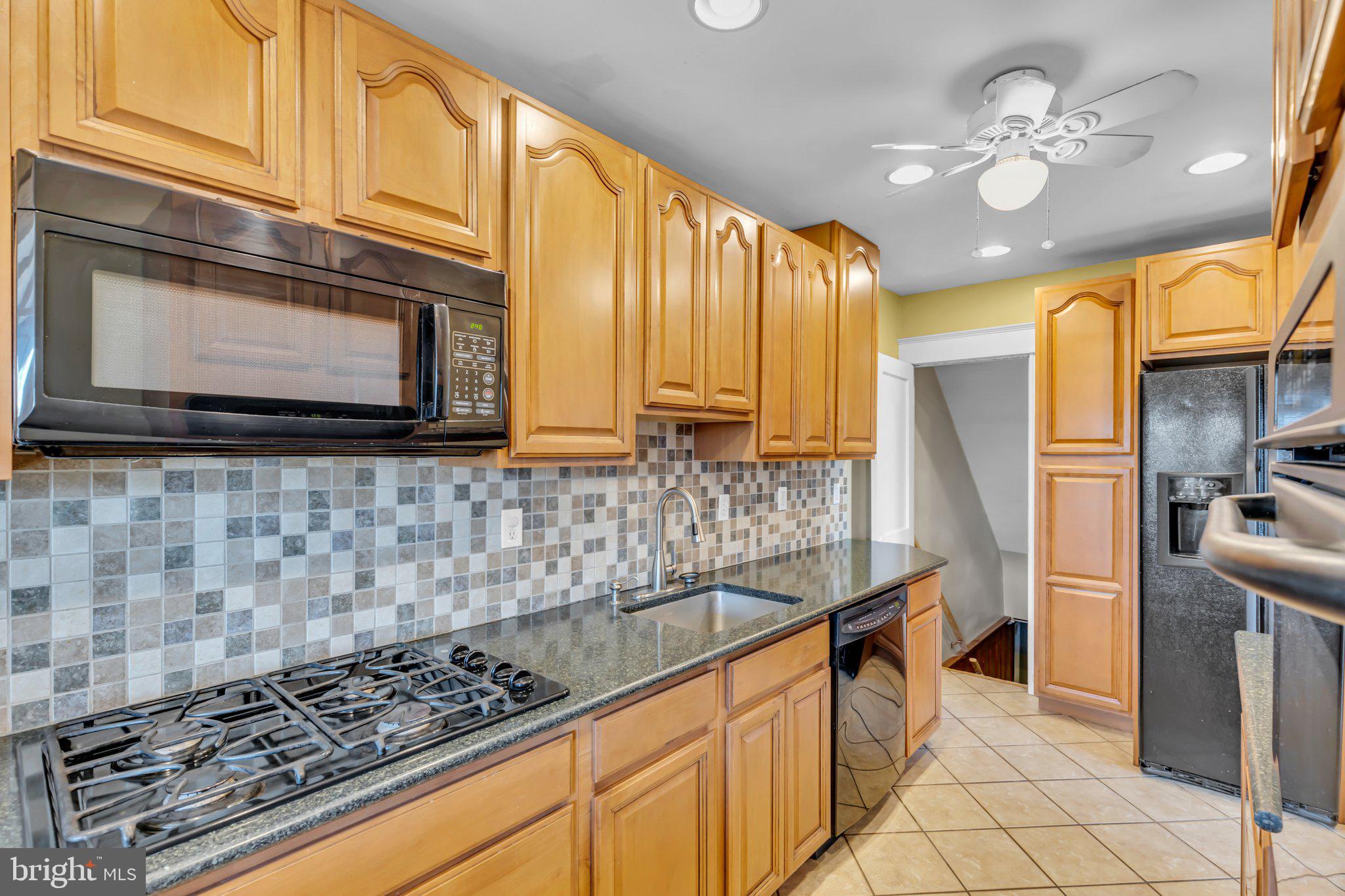 6147 Regent Park Road Catonsville, MD 21228 - Photo 7 of 22 a kitchen with stainless steel appliances granite countertop a stove a sink and a microwave