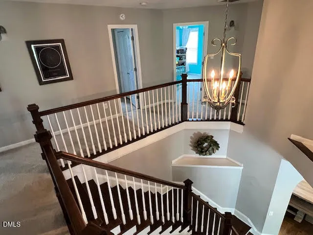 a view of a hallway with wooden floor and stairs