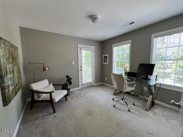 a view of a workspace with furniture and a window