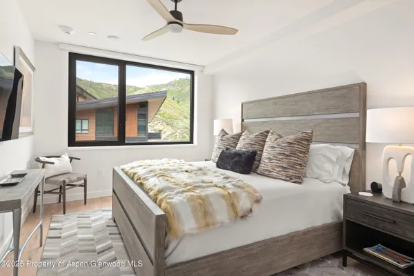 a large white bed sitting in a bedroom next to a window