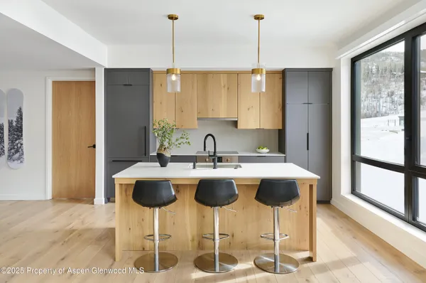 a kitchen with a dining table chairs and white cabinets