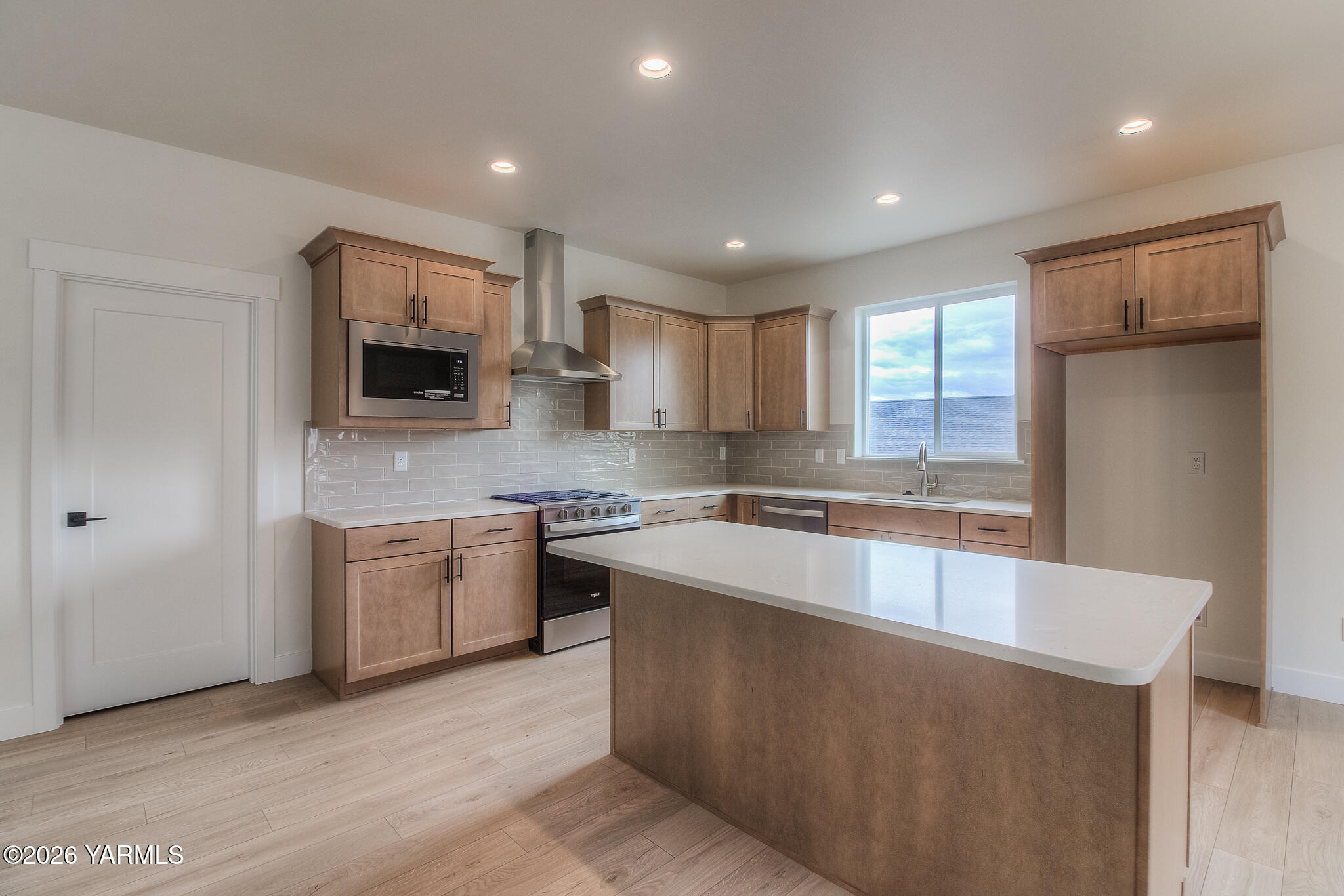 404 South 90th Avenue Yakima, WA 98908 - Photo 11 of 20 a large kitchen with stainless steel appliances granite countertop a sink a stove a refrigerator a center island and a window
