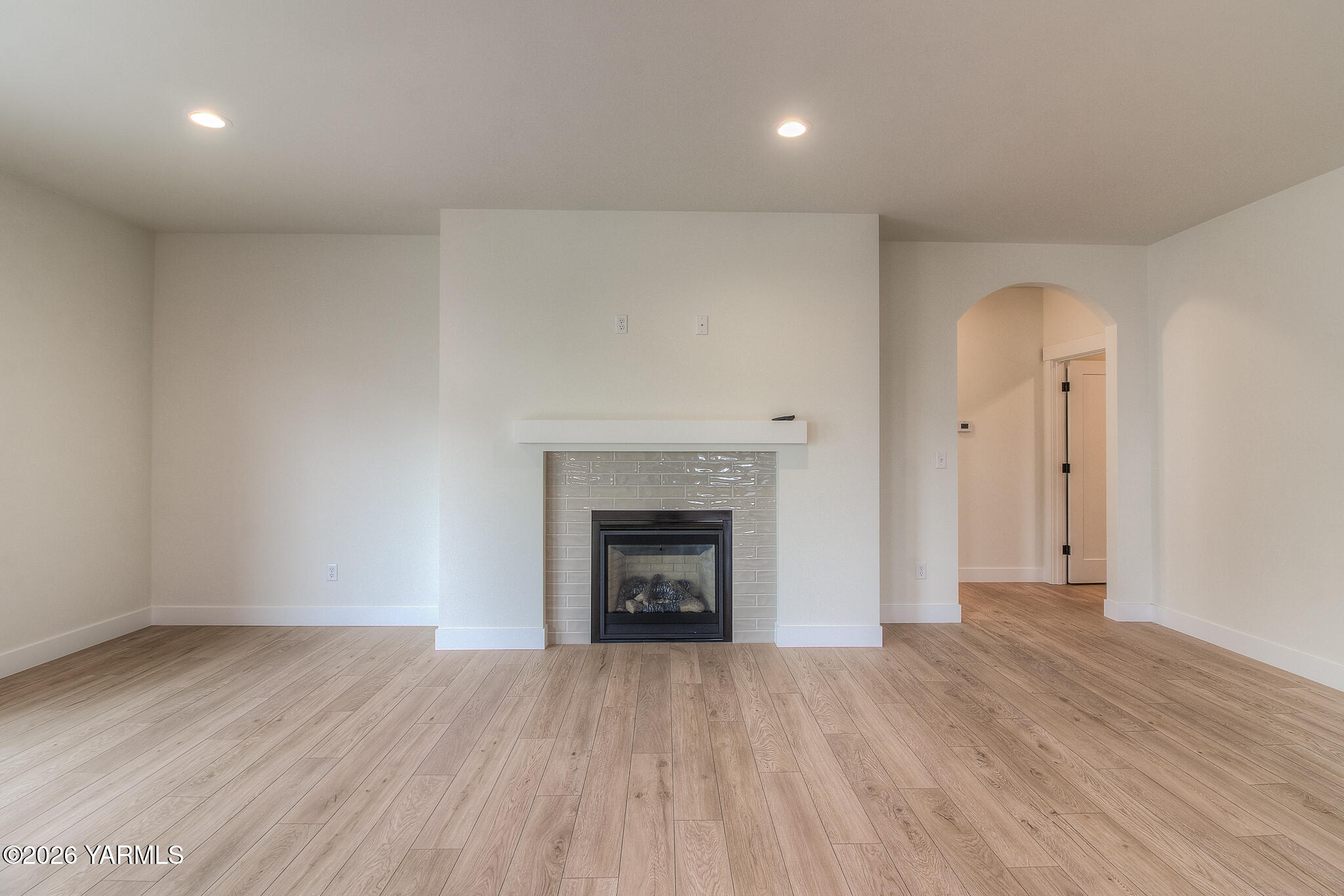 404 South 90th Avenue Yakima, WA 98908 - Photo 5 of 20 an empty room with wooden floor fireplace and windows