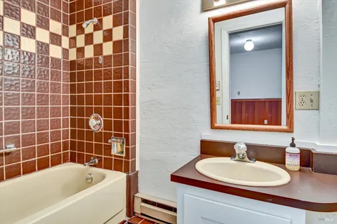 a bathroom with a sink a bathtub and a mirror