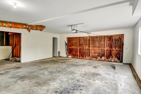 a view of an empty room with wooden floor and windows