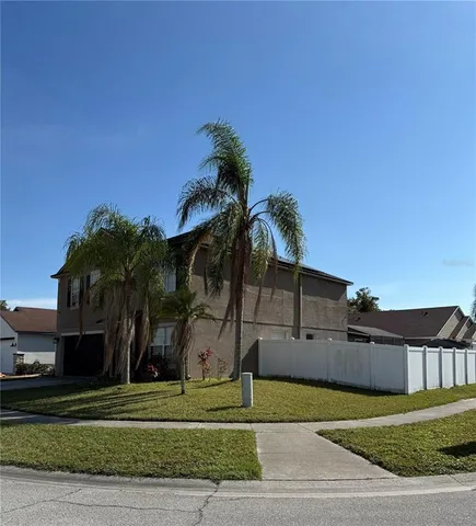 a palm tree sitting in front of a house