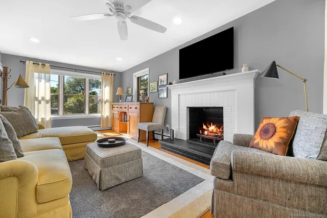 a living room with furniture a fireplace and a flat screen tv