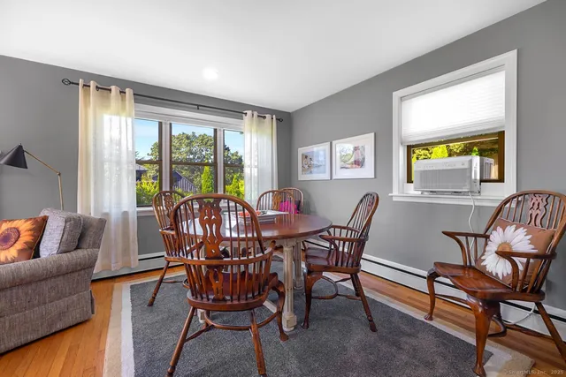 a view of a dining room with furniture a rug and wooden floor