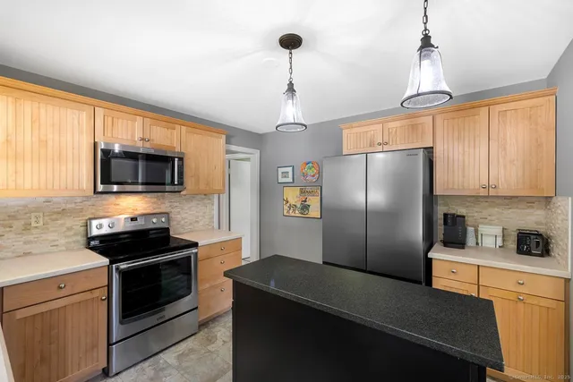 a kitchen with stainless steel appliances granite countertop a refrigerator a stove a sink and a microwave