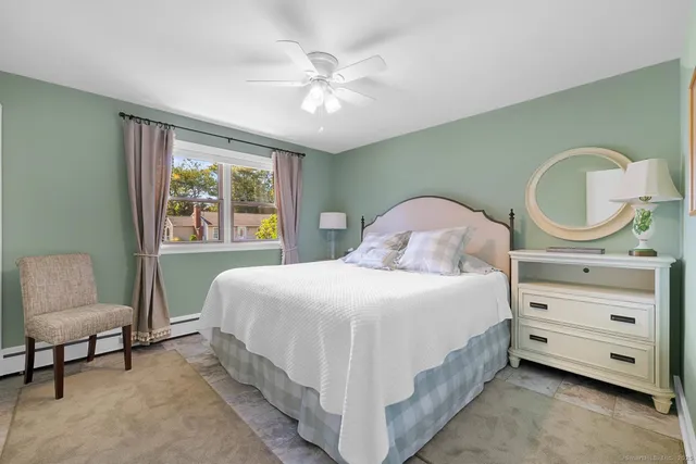 a bedroom with a bed a chandelier and a window