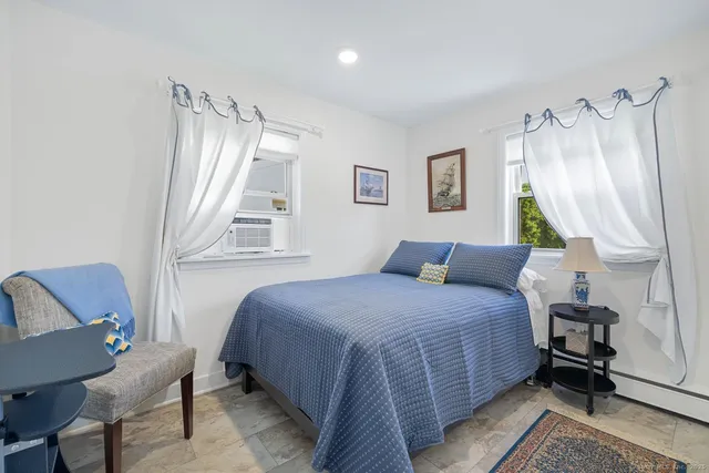 a bedroom with a bed wooden floor and a window
