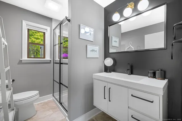 a bathroom with a toilet sink and mirror