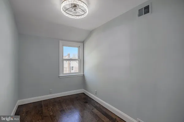 a view of a small space with wooden floor and a window