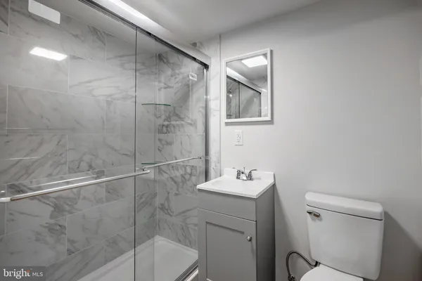 a bathroom with a shower a sink and toilet