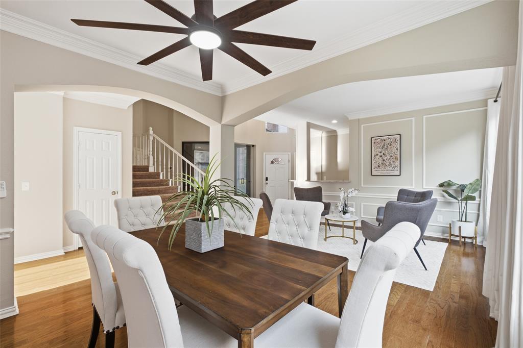 3903 Rive Lane Addison, TX 75001 - Photo 12 of 40 A generously sized formal dining room featuring crown molding, decorative wall trim, a statement ceiling fan, and elegant arched doorways connecting it to both the formal living room and the main hall. This space is made to host.