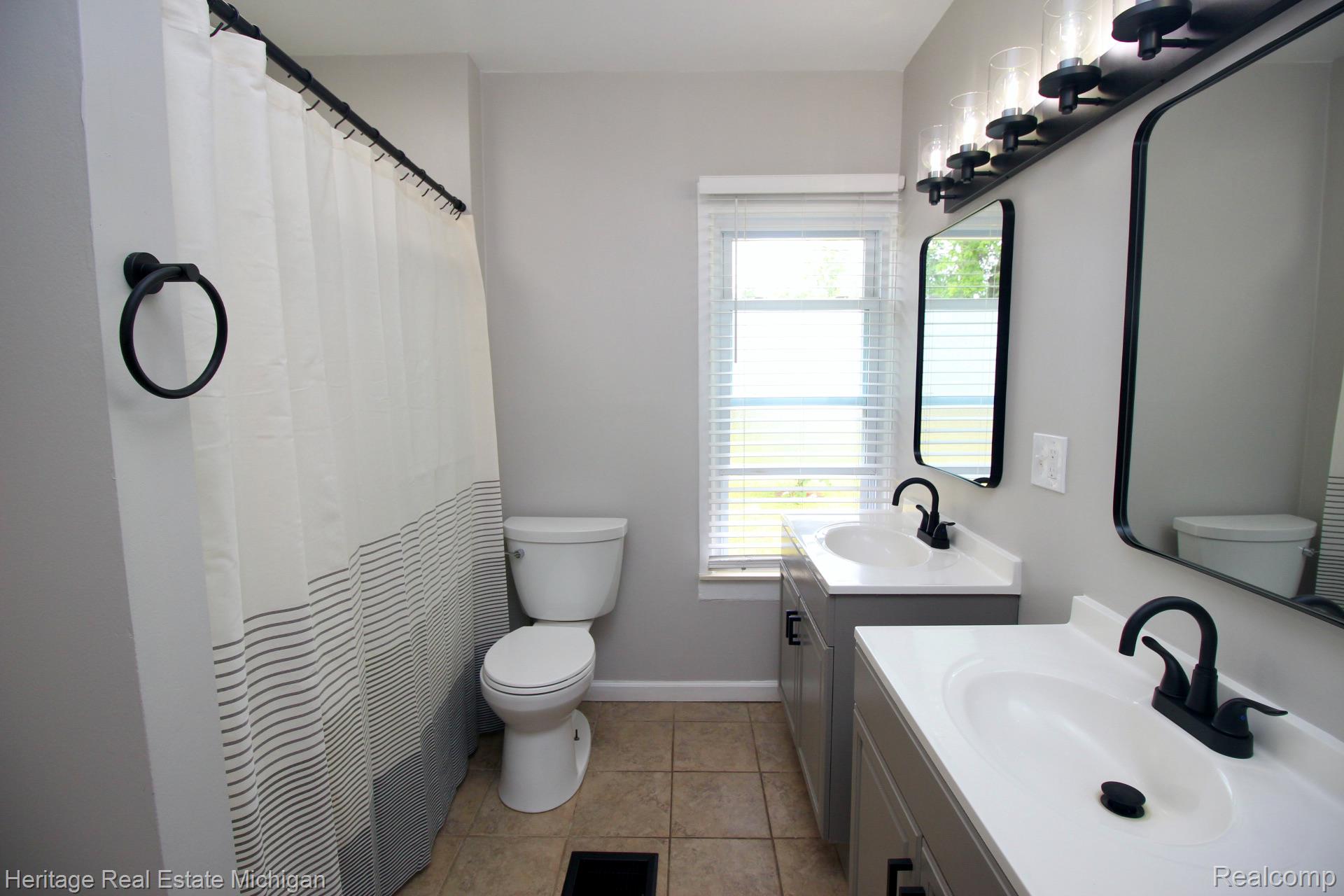 15352 South Duffield Road Byron, MI 48418 - Photo 15 of 47 Dual vanity with integrated sinks, matte black faucets, and rectangular mirrors