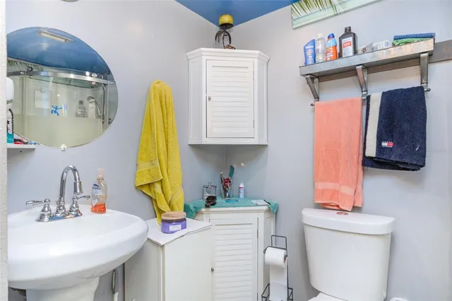 a bathroom with a sink a toilet and a mirror