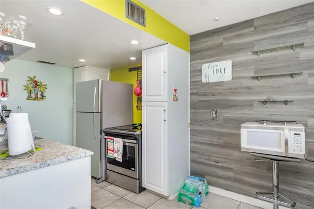 a kitchen with stainless steel appliances granite countertop a refrigerator and a stove