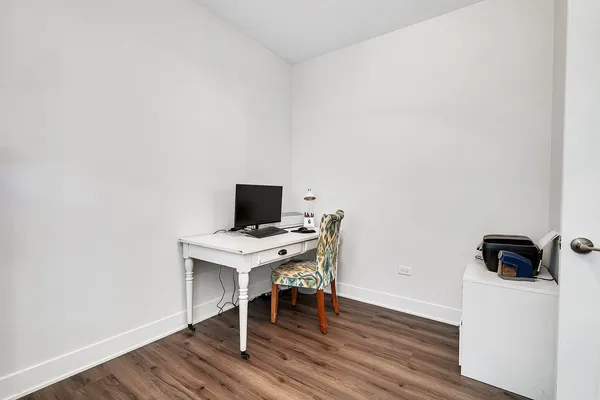 a view of a workspace with furniture and wooden floor